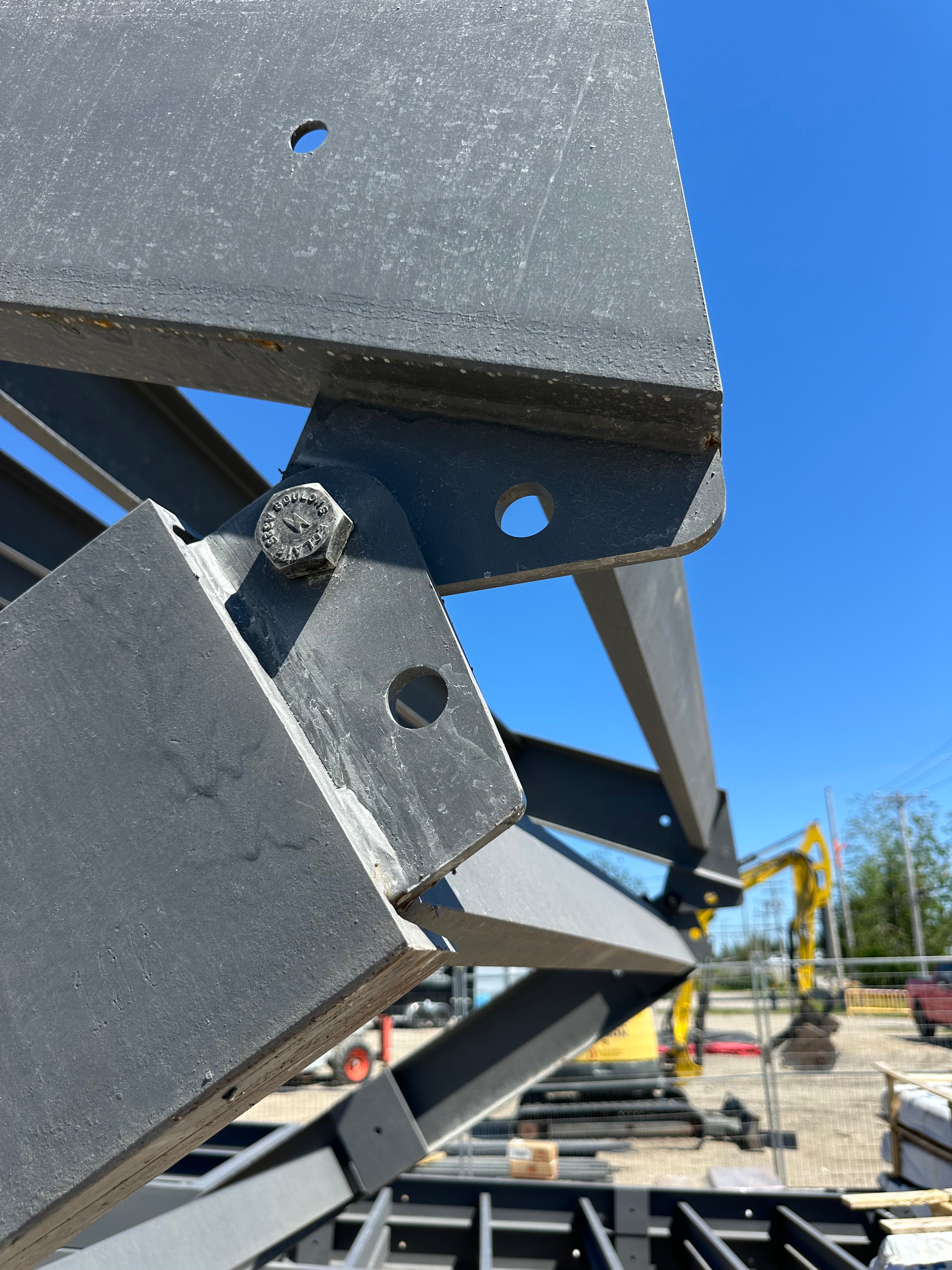Close-up of metal construction equipment against a blue sky